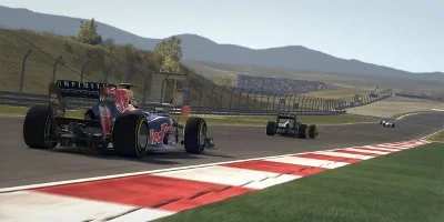 A Red Bull, along with other cars, racing down a long straight