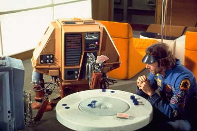 Freeman Lowell Playing A Card Game With Two Drones